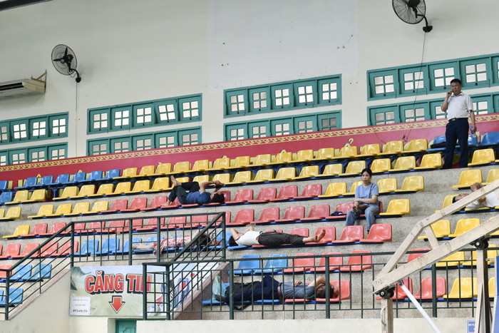 Nhiều cha mẹ nằm nghỉ trên hàng ghế trống trong nhà thi đấu của trường trong khi con làm bài thi. Nhiều cha mẹ nằm nghỉ trên hàng ghế trống trong nhà thi đấu của trường trong khi con làm bài thi.