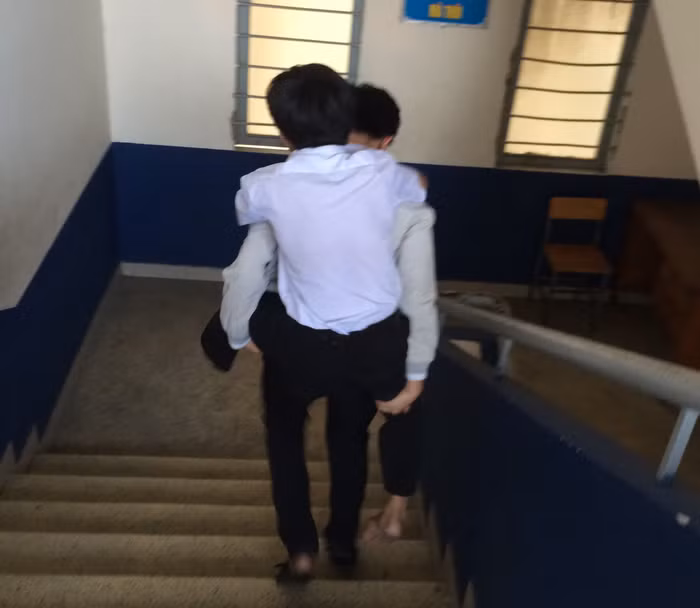 Các học sinh thay phiên nhau, mỗi bạn cõng Sang ba ngày - ảnh: T.A