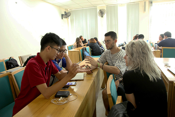Sinh viên Trường Đại học Kinh tế, Đại học Quốc gia Hà Nội trao đổi cùng các sinh viên nước ngoài. (Ảnh: Website nhà trường) sv truong dh kinh te dhqghn.png