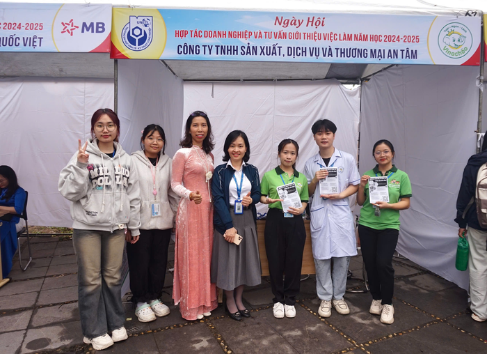 Chị Phạm Thị Thu Hường (áo dài hồng) - Trưởng phòng Hành chính nhân sự, Công ty Trách nhiệm hữu hạn sản xuất dịch vụ và thương mại An Tâm cùng các bạn nhân viên tại buổi tư vấn việc làm. (Ảnh: An Vy) gdvn-pham thi thu huong.png
