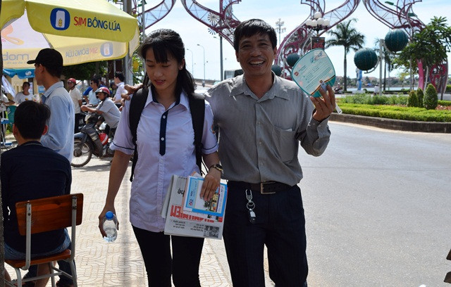 Hai bố con vui vẻ rời khu vực thi sau khi con gái hoàn thành bài thi môn Ngữ Văn. (Ảnh: Thủy Phan)