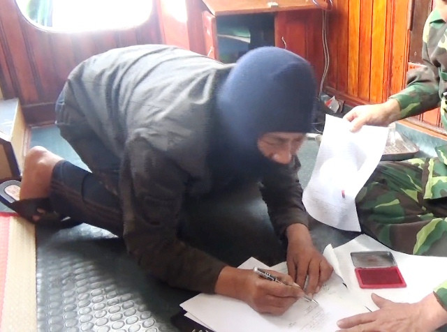 Một trong nhiều ngư dân trên tàu Trung Quốc ký vào biên bản vi phạm. (Ảnh: BĐBP cung cấp) Một trong nhiều ngư dân trên tàu Trung Quốc ký vào biên bản vi phạm. (Ảnh: BĐBP cung cấp)