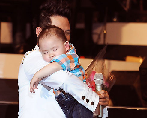 Nam ca sĩ xuống tận dưới sân khấu để ân cần đón con trai út từ tay vợ.