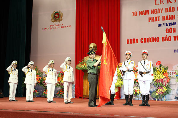 Thừa ủy quyền của Chủ tịch nước, Bộ trưởng Tô Lâm gắn Huân chương Bảo vệ Tổ quốc hạng nhất lên Cờ truyền thống của Báo Công an Nhân dân. Thừa ủy quyền của Chủ tịch nước, Bộ trưởng Tô Lâm gắn Huân chương Bảo vệ Tổ quốc hạng nhất lên Cờ truyền thống của Báo Công an Nhân dân.