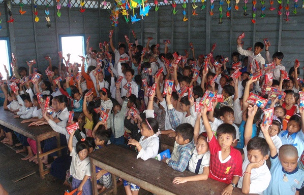 Phụ huynh và học sinh nhận quà tài trợ của khách du lịch đến từ Việt Nam.