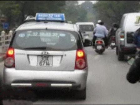 Chiếc taxi mà bé 1-2 tuổi cùng cầm vô-lăng với tài xế đang phóng trên đường phố đông đúc - Ảnh cắt từ clip