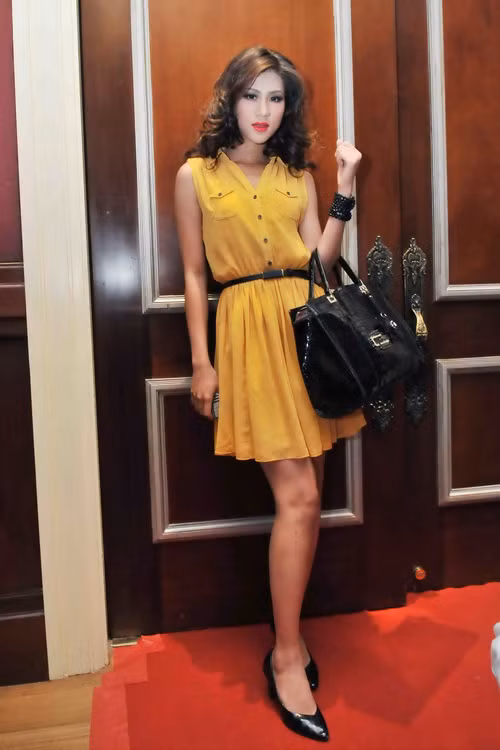 Trong chiếc váy liền thân màu vàng, Kim Dung thật thông minh trong việc kết hợp đeo dây lưng, túi xách, và đi giày cùng tone màu đen. Kiểu tóc xõa bồng bềnh rất hợp với chiếc váy.