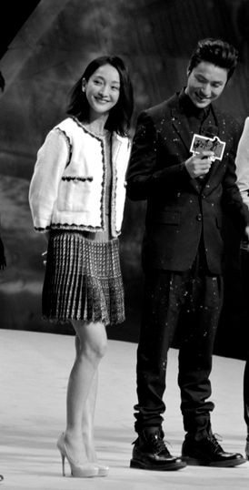 Châu Tấn mặc áo vải thô màu trắng kết hợp với váy xếp li lưng cao, phối hợp màu trắng cùng màu ghi thanh nhã, lịch sự.