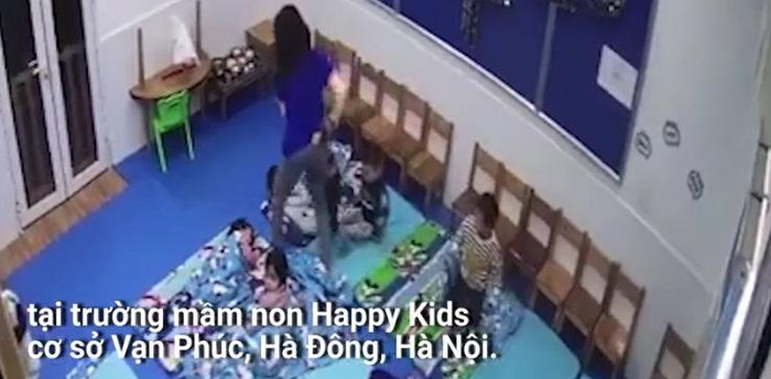 Cô giáo đang xốc trẻ đưa ra ngoài cửa (Ảnh cắt từ clip) Cô giáo đang xốc trẻ đưa ra ngoài cửa (Ảnh cắt từ clip)