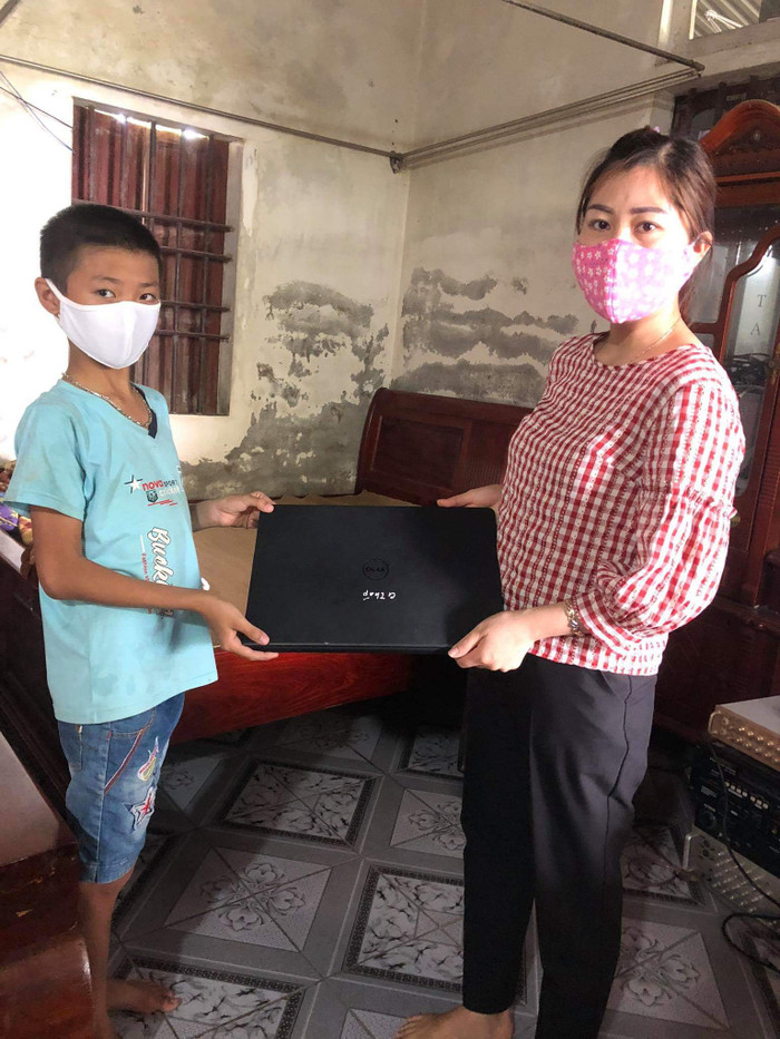 Cô Ngô Thị Báu, cán bộ văn phòng trao máy tính hỗ trợ học sinh học trực tuyến (Ảnh nhà trường cung cấp). Cô Ngô Thị Báu, cán bộ văn phòng trao máy tính hỗ trợ học sinh học trực tuyến (Ảnh nhà trường cung cấp).