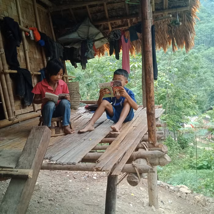 Học sinh Trường Tiểu học Hữu Khuông đang đọc sách truyện mà các thầy cô mang tới (Ảnh do Phòng Giáo dục huyện Tương Dương cung cấp).