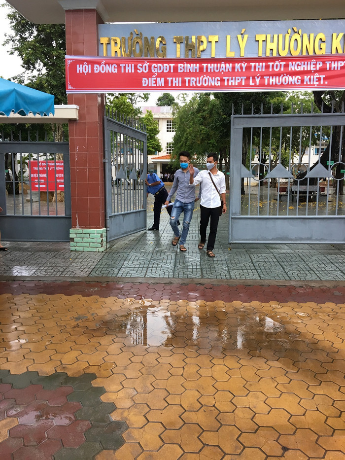 Hai học sinh đầu tiên rời phòng thi giơ tay vẫy chào đội tình nguyện (Ảnh Phan Tuyết)