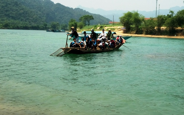 Nguy hiểm luôn rình rập trên những con thuyền gỗ nhỏ bé chở người qua sông. (Ảnh: Thủy Phan)