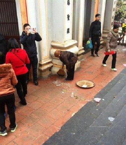 Cặm cụi quét, vét từng chút gạo sau khi bị khách hành lễ vãi đi (Ảnh: Đào Tiến Vinh) Cặm cụi quét, vét từng chút gạo sau khi bị khách hành lễ vãi đi (Ảnh: Đào Tiến Vinh)