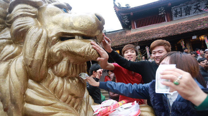 Người dân đi hội chùa Hương chen nhau bôi tiền, nhét tiền vào miệng sư tử đá trước chùa Thiên Trù - (Ảnh: Tiến Thành - Tuổi trẻ) Người dân đi hội chùa Hương chen nhau bôi tiền, nhét tiền vào miệng sư tử đá trước chùa Thiên Trù - (Ảnh: Tiến Thành - Tuổi trẻ)
