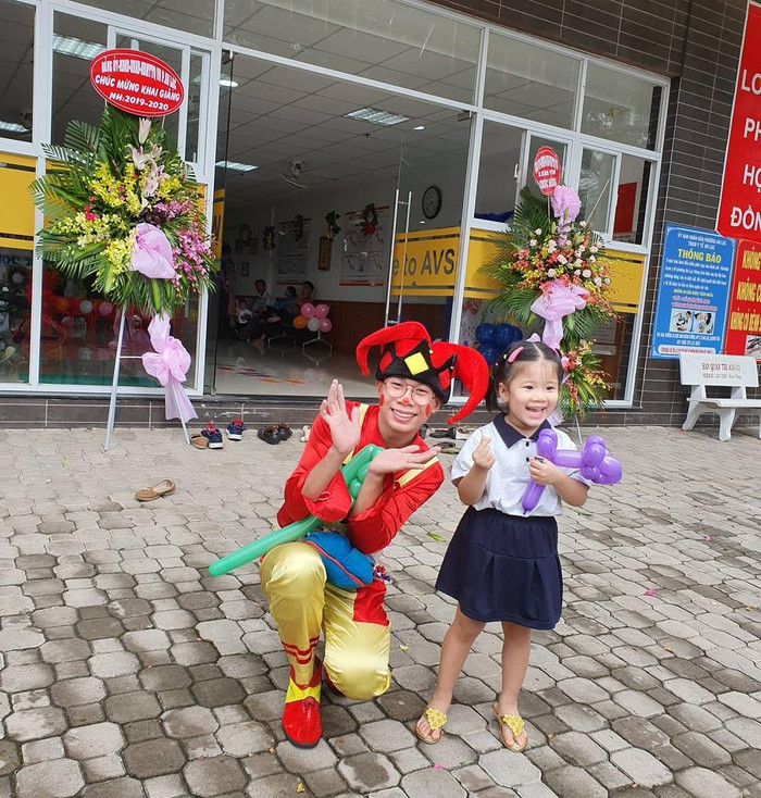 Chú hề đứng ngoài cổng để đón và tặng quà cho các bé vào trường (Ảnh CTV) Chú hề đứng ngoài cổng để đón và tặng quà cho các bé vào trường (Ảnh CTV)