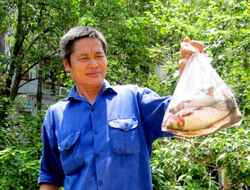 Anh Đỗ Văn Hùng khoe túi cá vớt được. Anh Đỗ Văn Hùng khoe túi cá vớt được.