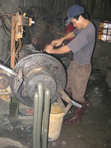Công nhân đưa nguyên liệu vào máy nấu thành những dải nhựa Công nhân đưa nguyên liệu vào máy nấu thành những dải nhựa
