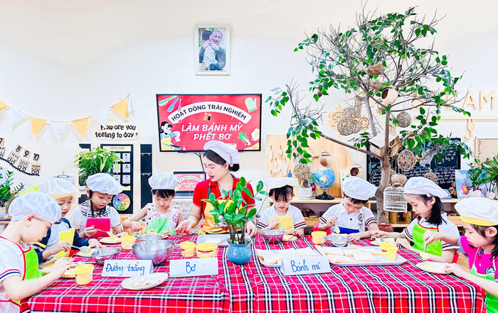 Huyền Trang dạy các em nhỏ làm bánh mì phết bơ trong kì thực tập (Ảnh: NVCC) THỰC TẬP 01.jpg