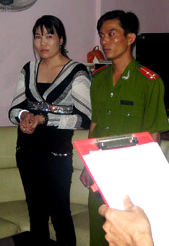 Bà Anh nghe đọc lệnh bắt. Ảnh: Nguyễn Hùng Bà Anh nghe đọc lệnh bắt. Ảnh: Nguyễn Hùng