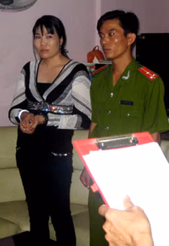 Bà Anh nghe đọc lệnh bắt. Ảnh: Nguyễn Hùng