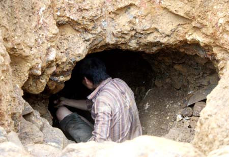 Một thanh niên đang mải khoét hầm tìm vàng. f