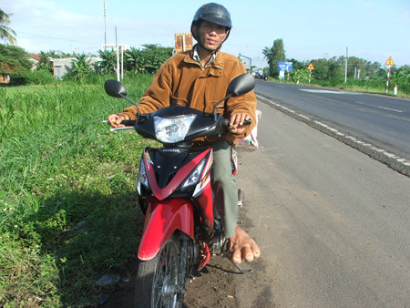 Tuy đi lại khó khăn nhưng anh Tài vẫn điều khiển xe mô tô bình thường Tuy đi lại khó khăn nhưng anh Tài vẫn điều khiển xe mô tô bình thường