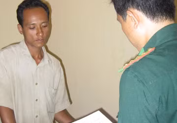 Danh Thanh Phương nghe đọc quyết định tạm giữ tang vật. Ảnh: K.GIANG