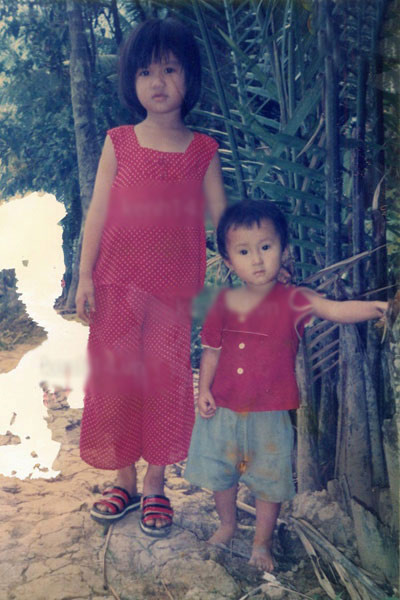 Dép lê, đồ hoa và đôi mắt to tròn, đen nhánh của cô bé "thôn quê" Ngọc Trinh lấm lém đất bùn. Ảnh: Kênh 14.