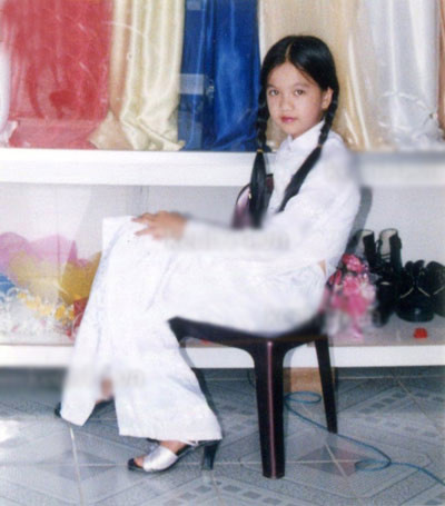 Thiếu nữ Ngọc Trinh ngây thơ và thánh thiện trong tà áo dài trắng. Với mái tóc dài thắt bím hai bên, cùng vẻ bén lén và rụt rè khi chụp hình trông cô đáng yêu và khác hẳn bây giờ. Ảnh: Kênh 14.