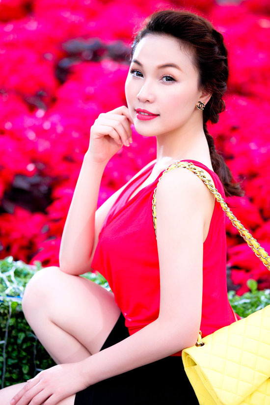 Cô diện chiếc áo và túi với màu sắc bắt mắt. Mẫu áo được thiết kế theo xu hướng cut-out khoe trọn phần võng lưng gợi cảm