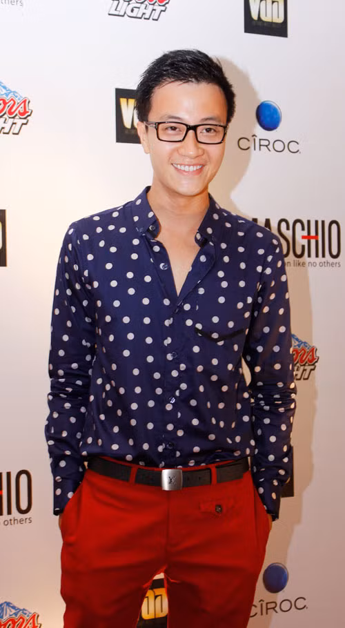 Áo xanh chấm bi trắng đi kèm với quần đỏ rực, lại bonus thêm cặp kính cận khá teen. Như thế này thì làm sao các ống kính và đèn flash có thể rời mắt khỏi anh ấy được nhỉ?