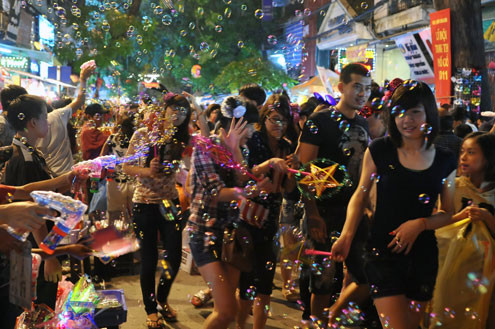 Tối 10/9, chợ đồ chơi Hàng Mã, Hàng Lược, Lương Văn Can, Hàng Đường... đông nghẹt người dạo chơi, tham quan, mua sắm. Trước đêm trung thu 2 ngày, dòng người chen lấn mua đồ chơi. Hai cô gái trẻ đứng giữa đoàn người qua lại ngắm nghía mình qua chiếc gương. Các cửa hàng bày hàng tràn lan ra đường làm thu hẹp không gian thưởng ngoạn của người chơi. Giải pháp cho bé ngồi trên vai là cách chống chen bẹp người của nhiều ông bố. Nạn bắn súng bong bóng xà phòng vào người đi đường vẫn tiếp diễn. Ôtô len vào nơi này cũng gặp khó khăn. Tài xế phải thò đầu ra nhờ mọi người tránh đường. Nhiều hàng bày bán lấn chiếm lòng lề đường khiến lực lượng bảo vệ phải liên tục làm việc. Và đội quân bán rong lại cầm ghế, bê hàng chạy sang chỗ khác. Những chiếc mặt nạ quái đản lại xuất hiện. Tối 10/9, chợ đồ chơi Hàng Mã, Hàng Lược, Lương Văn Can, Hàng Đường... đông nghẹt người dạo chơi, tham quan, mua sắm. Trước đêm trung thu 2 ngày, dòng người chen lấn mua đồ chơi. Hai cô gái trẻ đứng giữa đoàn người qua lại ngắm nghía mình qua chiếc gương. Các cửa hàng bày hàng tràn lan ra đường làm thu hẹp không gian thưởng ngoạn của người chơi. Giải pháp cho bé ngồi trên vai là cách chống chen bẹp người của nhiều ông bố. Nạn bắn súng bong bóng xà phòng vào người đi đường vẫn tiếp diễn. Ôtô len vào nơi này cũng gặp khó khăn. Tài xế phải thò đầu ra nhờ mọi người tránh đường. Nhiều hàng bày bán lấn chiếm lòng lề đường khiến lực lượng bảo vệ phải liên tục làm việc. Và đội quân bán rong lại cầm ghế, bê hàng chạy sang chỗ khác. Những chiếc mặt nạ quái đản lại xuất hiện.