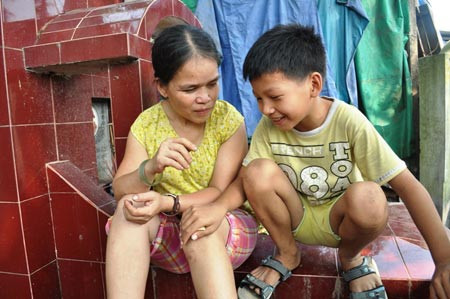 Hai mẹ con ngồi trên chiếc mộ cạnh “nhà” - nơi dùng để tiếp khách.