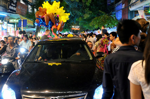 Tối 10/9, chợ đồ chơi Hàng Mã, Hàng Lược, Lương Văn Can, Hàng Đường... đông nghẹt người dạo chơi, tham quan, mua sắm. Trước đêm trung thu 2 ngày, dòng người chen lấn mua đồ chơi. Hai cô gái trẻ đứng giữa đoàn người qua lại ngắm nghía mình qua chiếc gương. Các cửa hàng bày hàng tràn lan ra đường làm thu hẹp không gian thưởng ngoạn của người chơi. Giải pháp cho bé ngồi trên vai là cách chống chen bẹp người của nhiều ông bố. Nạn bắn súng bong bóng xà phòng vào người đi đường vẫn tiếp diễn. Ôtô len vào nơi này cũng gặp khó khăn. Tài xế phải thò đầu ra nhờ mọi người tránh đường. Nhiều hàng bày bán lấn chiếm lòng lề đường khiến lực lượng bảo vệ phải liên tục làm việc. Và đội quân bán rong lại cầm ghế, bê hàng chạy sang chỗ khác. Những chiếc mặt nạ quái đản lại xuất hiện. Tối 10/9, chợ đồ chơi Hàng Mã, Hàng Lược, Lương Văn Can, Hàng Đường... đông nghẹt người dạo chơi, tham quan, mua sắm. Trước đêm trung thu 2 ngày, dòng người chen lấn mua đồ chơi. Hai cô gái trẻ đứng giữa đoàn người qua lại ngắm nghía mình qua chiếc gương. Các cửa hàng bày hàng tràn lan ra đường làm thu hẹp không gian thưởng ngoạn của người chơi. Giải pháp cho bé ngồi trên vai là cách chống chen bẹp người của nhiều ông bố. Nạn bắn súng bong bóng xà phòng vào người đi đường vẫn tiếp diễn. Ôtô len vào nơi này cũng gặp khó khăn. Tài xế phải thò đầu ra nhờ mọi người tránh đường. Nhiều hàng bày bán lấn chiếm lòng lề đường khiến lực lượng bảo vệ phải liên tục làm việc. Và đội quân bán rong lại cầm ghế, bê hàng chạy sang chỗ khác. Những chiếc mặt nạ quái đản lại xuất hiện.