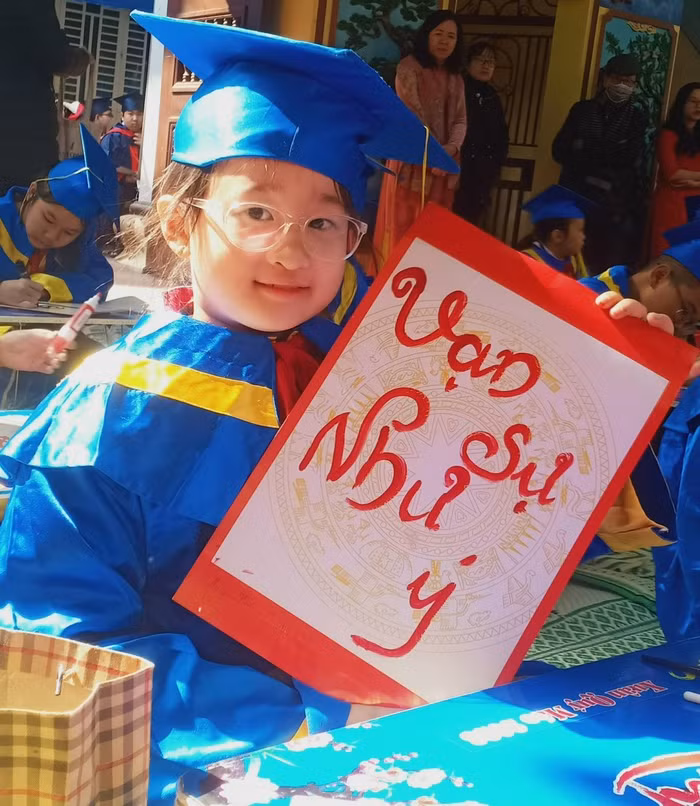 Học sinh hứng khởi khoe thành quả khai bút đầu xuân.(Ảnh: Phạm Linh)
