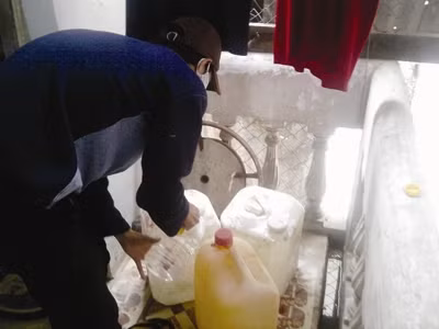 Đầu nậu đang pha methanol vào can xăng để đi giao cho các cửa hàng. (Nguồn Tiền Phong)