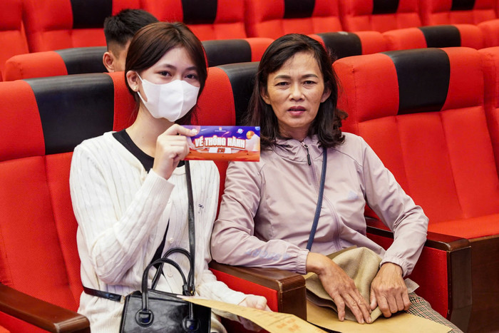 Một nữ sinh chụp ảnh kỷ niệm ngày nhập học cùng người thân, trên tay là tấm vé thông hành dành cho tân sinh viên khóa 13. Ảnh: NTCC 459571989_950056417162282_7412280814639577458_n.jpg