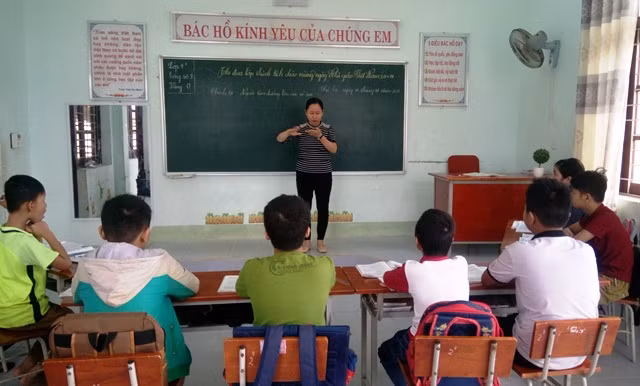 Cô Nguyễn Thị Ngọc Dung dạy cho các em học sinh khiếm thính bằng ngôn ngữ ký hiệu. (Ảnh: T.P)
