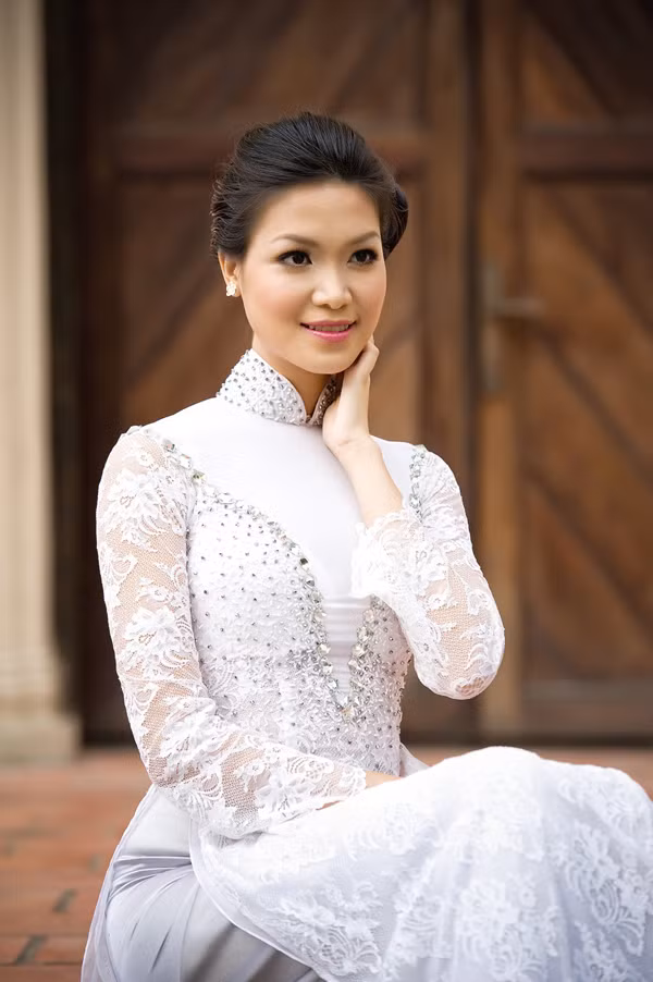 Hoa hậu Việt Nam 2008 Thùy Dung diện áo dài ren trắng, e ấp yêu kiều, trong bóng chiều hoàng hôn đang dần trải xuống ngôi thánh đường. (Theo Ngôi Sao)