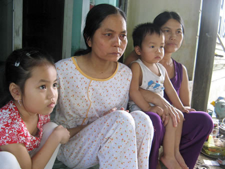 Cuộc sống khó khăn, Mai (áo sáng) và hai con phải nương nhờ mẹ già (bìa phải)