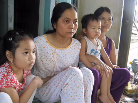 Cuộc sống khó khăn, Mai (áo sáng) và hai con phải nương nhờ mẹ già (bìa phải)