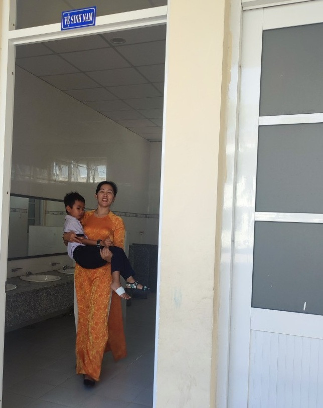 Giáo viên bồng học sinh bị mệt đi vệ sinh (Ảnh tác giả) gdvn-giáo viên bồng hs.jpg