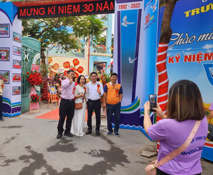 Cựu học sinh chụp ảnh kỷ niệm ngày đặc biệt về thăm mái trường xưa (Ảnh: Phạm Linh)