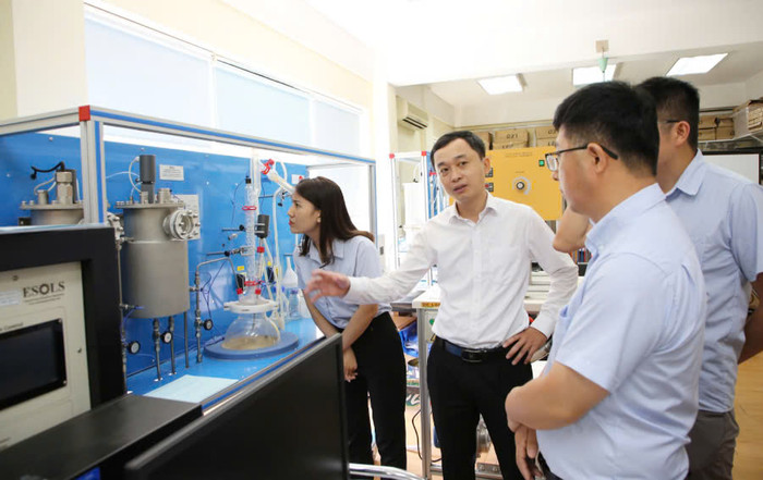 Tiến sĩ Bùi Đình Tú (giữa ảnh) giới thiệu phòng thực hành Khoa Vật lý kỹ thuật và công nghệ nano. Ảnh: NTCC. z6372367649573_f82fe4a4e56e9fec886dbcb429282d02.jpg