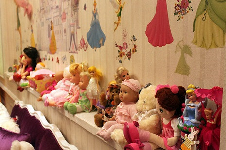 Cô bé có rất nhiều đồ chơi như búp bê và thú nhồi bông.