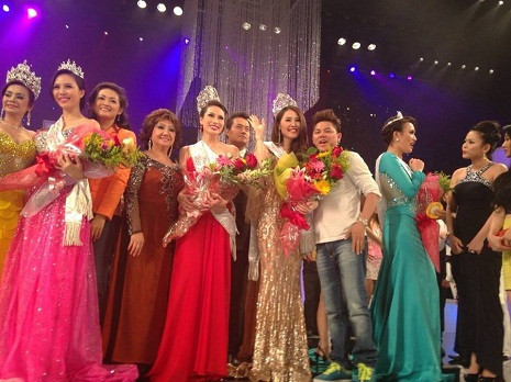 Cô đứng trên sân khấu chụp hình cùng các thí sinh khác.