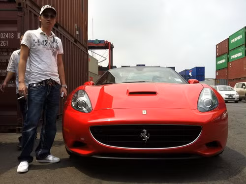 Đỗ Bình Dương tạo dáng bên siêu xe Ferrari California màu đỏ đời 2010.
