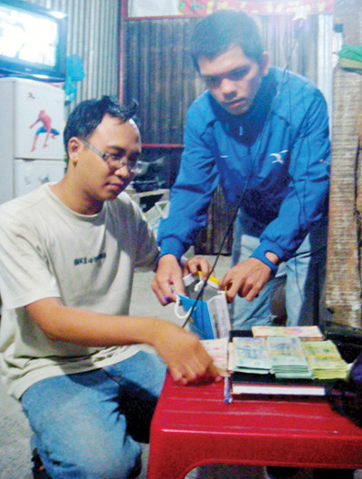 Trước khi đi chuộc xe, Đinh Đắc Lộc (ngồi) đã cùng với "hiệp sĩ" chuẩn bị tiền trong nhà trọ - Ảnh: do "hiệp sĩ" CLB phòng chống tội phạm P. Phú Hòa cung cấp Trước khi đi chuộc xe, Đinh Đắc Lộc (ngồi) đã cùng với "hiệp sĩ" chuẩn bị tiền trong nhà trọ - Ảnh: do "hiệp sĩ" CLB phòng chống tội phạm P. Phú Hòa cung cấp