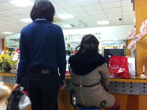 Khách hàng nhấp nhổm đợi đến lượt để thực hiện giao dịch.